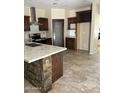 Modern kitchen features dark cabinets, stainless steel appliances, stone accents, and a large island at 7163 W Lamar Rd, Glendale, AZ 85303
