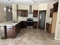 Modern kitchen features dark cabinets, stainless steel appliances, stone accents, and a large island at 7163 W Lamar Rd, Glendale, AZ 85303