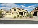 Two-story home with a three-car garage and desert landscaping for a low-maintenance, water-wise front yard at 7511 S 45Th Dr, Laveen, AZ 85339