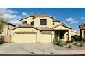 Exterior shot of a tan two-story home with a spacious three-car garage and a low-maintenance landscaped yard at 7511 S 45Th Dr, Laveen, AZ 85339