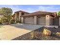 Spacious three car garage with neutral doors and desert landscaping at 76 W Stacey Ln, Tempe, AZ 85284