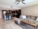 Open living space featuring wooden flooring, a ceiling fan, and an inviting gray couch at 7920 E Camelback Rd # 203, Scottsdale, AZ 85251