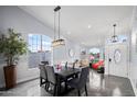 Dining room with large windows, a modern light fixture, and neutral colored furnishings at 9818 W Pontiac Dr, Peoria, AZ 85382