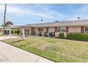 Well-kept single story home with lush green lawn and covered parking at 10815 W Hatcher Rd, Sun City, AZ 85351
