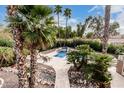 Inviting backyard oasis showcasing a sparkling pool, spa, and lush tropical landscaping at 11101 W Sieno Pl, Avondale, AZ 85392
