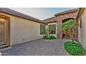 Private courtyard with brick pavers, desert plants, and elegant entrance at 15430 W Sells Dr, Goodyear, AZ 85395