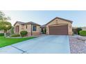 Inviting home featuring manicured lawn, desert landscaping, and a two-car attached garage at 15430 W Sells Dr, Goodyear, AZ 85395