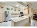 Well-lit kitchen featuring a breakfast bar, stainless steel refrigerator, and lots of white cabinets at 17094 N Silver Path, Surprise, AZ 85374