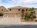 Two-story home featuring a three-car garage, desert landscaping, and well-maintained lawn at 22139 N O Sullivan Dr, Maricopa, AZ 85138