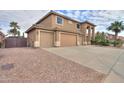 A two-story home featuring a three-car garage, desert landscaping, and a tile roof at 22139 N O Sullivan Dr, Maricopa, AZ 85138