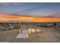 Single-story home featuring a modern garage door, clean white facade, and picturesque desert surroundings at sunset at 28834 N 175Th Ave, Surprise, AZ 85387