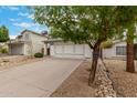 Two-story home showcasing a three-car garage, concrete driveway, and desert rock landscaping at 3630 W Camino Real --, Glendale, AZ 85310