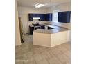 Eat-in kitchen featuring tile floors, neutral countertop, and navy blue cabinetry at 6527 W Adams St, Phoenix, AZ 85043