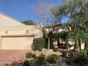 Charming home featuring a two-car garage, desert landscaping, and lovely curb appeal on a sunny day at 6701 N Scottsdale Rd # 15, Scottsdale, AZ 85250
