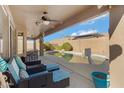 View of the pool from covered patio with ceiling fan and outdoor seating in landscaped backyard at 8544 E Ocaso Ave, Mesa, AZ 85212