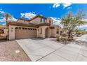 Two-story home featuring a spacious driveway leading to a two-car garage and desert landscaping in the front yard at 12887 N 93Rd Dr, Peoria, AZ 85381