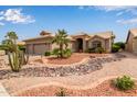Beautiful single-story home with desert landscaping featuring rocks, cactus, and palm trees at 15481 W Amelia Dr, Goodyear, AZ 85395