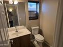 Cozy bathroom featuring a modern toilet and sink with a vanity mirror at 16317 N 152 Ave, Surprise, AZ 85374