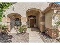 Inviting front porch with a decorative archway, seating, and a view of the desert-style landscape at 2535 N Pinnule Cir, Mesa, AZ 85215