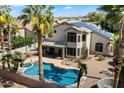Gorgeous backyard showcasing a pool, desert landscaping, mature palms, and an extended patio at 2702 S Beverly Pl, Chandler, AZ 85286
