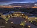 Dusk view of an expansive luxury home with desert landscaping, circle driveway, and beautiful distant city lights at 30556 N Sage Dr, Peoria, AZ 85383