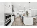 Modern white kitchen with stainless steel appliances, large island, and ample cabinet space at 33401 N 142Nd Way, Scottsdale, AZ 85262