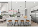 Bright, modern kitchen with stainless steel appliances, oversized island, and pendant lighting at 33401 N 142Nd Way, Scottsdale, AZ 85262