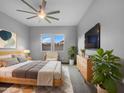 Calm primary bedroom with fan, plenty of natural light and contemporary furnishings at 41285 W Sussex Dr, Maricopa, AZ 85138