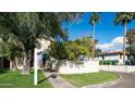 Exterior of a bright home featuring a green lawn, trees, and blue awnings over the windows at 8453 S 48Th St # 3, Phoenix, AZ 85044