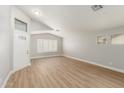 Bright living space with wood-style floors, front door with decorative glass, and plantation shutters at 8541 N 112Th Ave, Peoria, AZ 85345