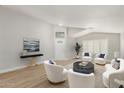 Staged living room with modern decor, wood floors, and ample seating area at 8541 N 112Th Ave, Peoria, AZ 85345
