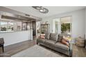 Open-concept living space including a gray sofa, open kitchen, and sliding glass doors to the patio at 9390 N 115Th St, Scottsdale, AZ 85259