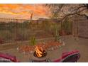 Inviting backyard with fire pit, seating area, desert landscaping, and mountain views at sunset at 10356 E Meandering Trail Ln, Gold Canyon, AZ 85118