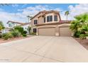 Charming tan home features a three-car garage, desert landscaping and a classic stucco facade at 1567 S Western Skies Dr, Gilbert, AZ 85296