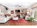Cozy living room featuring a fireplace, hardwood floors, and comfortable seating with plenty of natural light at 1567 S Western Skies Dr, Gilbert, AZ 85296
