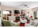Comfortable living room features a cozy fireplace, neutral tones, and a ceiling fan for added comfort at 1567 S Western Skies Dr, Gilbert, AZ 85296