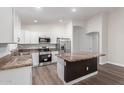 Kitchen features white cabinets, stainless steel appliances, granite countertops, and a large island at 19008 N Lousandra Dr, Maricopa, AZ 85138