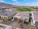 Aerial view of home with desert landscaping with golf course in back and tile roof at 20528 W Coolidge St, Buckeye, AZ 85396
