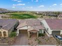 Aerial view of home with desert landscaping, with golf course in back and tile roof at 20528 W Coolidge St, Buckeye, AZ 85396