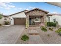 Charming home featuring a stone-accented porch and desert landscaping with a brick driveway at 20528 W Coolidge St, Buckeye, AZ 85396