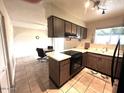 Functional kitchen featuring brown cabinetry, tile floors, and an adjacent dining area with lots of natural light at 2151 S Calle Del Marcos --, Casa Grande, AZ 85194