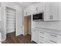Bright kitchen featuring white cabinets, stainless microwave, and tiled backsplash at 21539 S 191St Pl, Queen Creek, AZ 85140