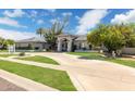 Stunning single-story home featuring a circular driveway, lush landscaping, and a welcoming entryway at 2251 N 32Nd St # 31, Mesa, AZ 85213