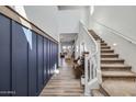 A view of the foyer featuring the staircase, wooden floors and a blue accent wall at 22752 E Arroyo Verde Dr, Queen Creek, AZ 85142
