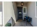 Charming front porch with black door, bench with blue pillows and hanging light fixture at 22752 E Arroyo Verde Dr, Queen Creek, AZ 85142