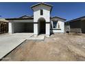 New construction exterior with open garage, arched entry, and simple landscaping at 22824 E Roundup Way, Queen Creek, AZ 85142