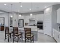 Modern kitchen boasts white cabinets, granite countertops, stainless steel appliances, and an island with seating at 24738 N 175Th Ave, Surprise, AZ 85387