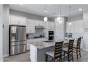 Bright kitchen with stainless steel appliances, a large island featuring seating, and white cabinets at 24738 N 175Th Ave, Surprise, AZ 85387