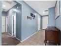 Long hallway featuring light blue walls, neutral flooring, and white doors leading to various rooms at 35730 N Pommel Pl, San Tan Valley, AZ 85144