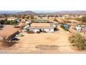 Aerial shot featuring a home, RV parking, a green car, and horse facilities in a desert landscape at 404 W Galvin St, Phoenix, AZ 85086